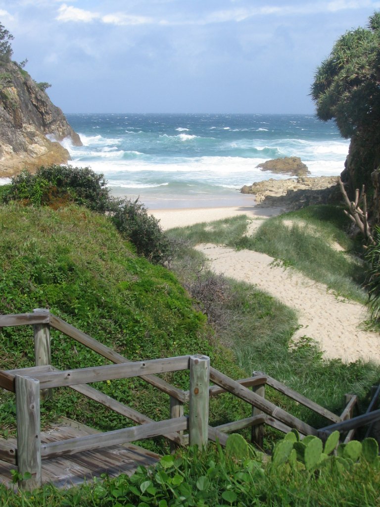 a beach front with steps going to the ocean