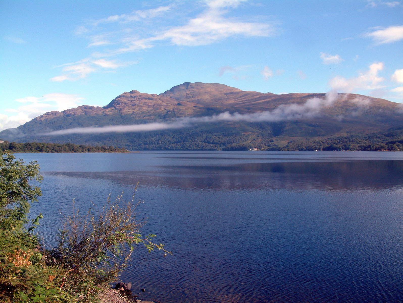 a lake in the mountains that has some clouds