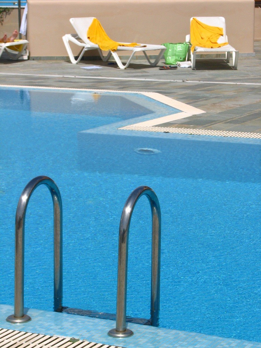 a large blue swimming pool with a safety rail