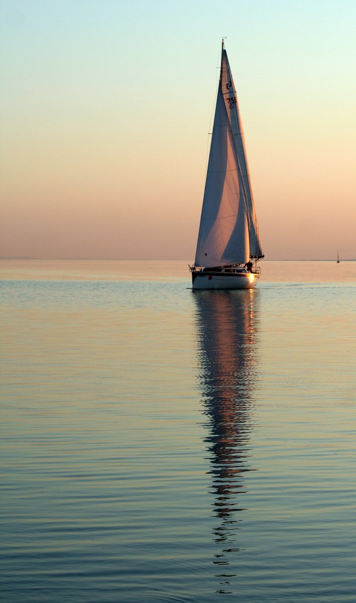 a sail boat on the water with a sky background