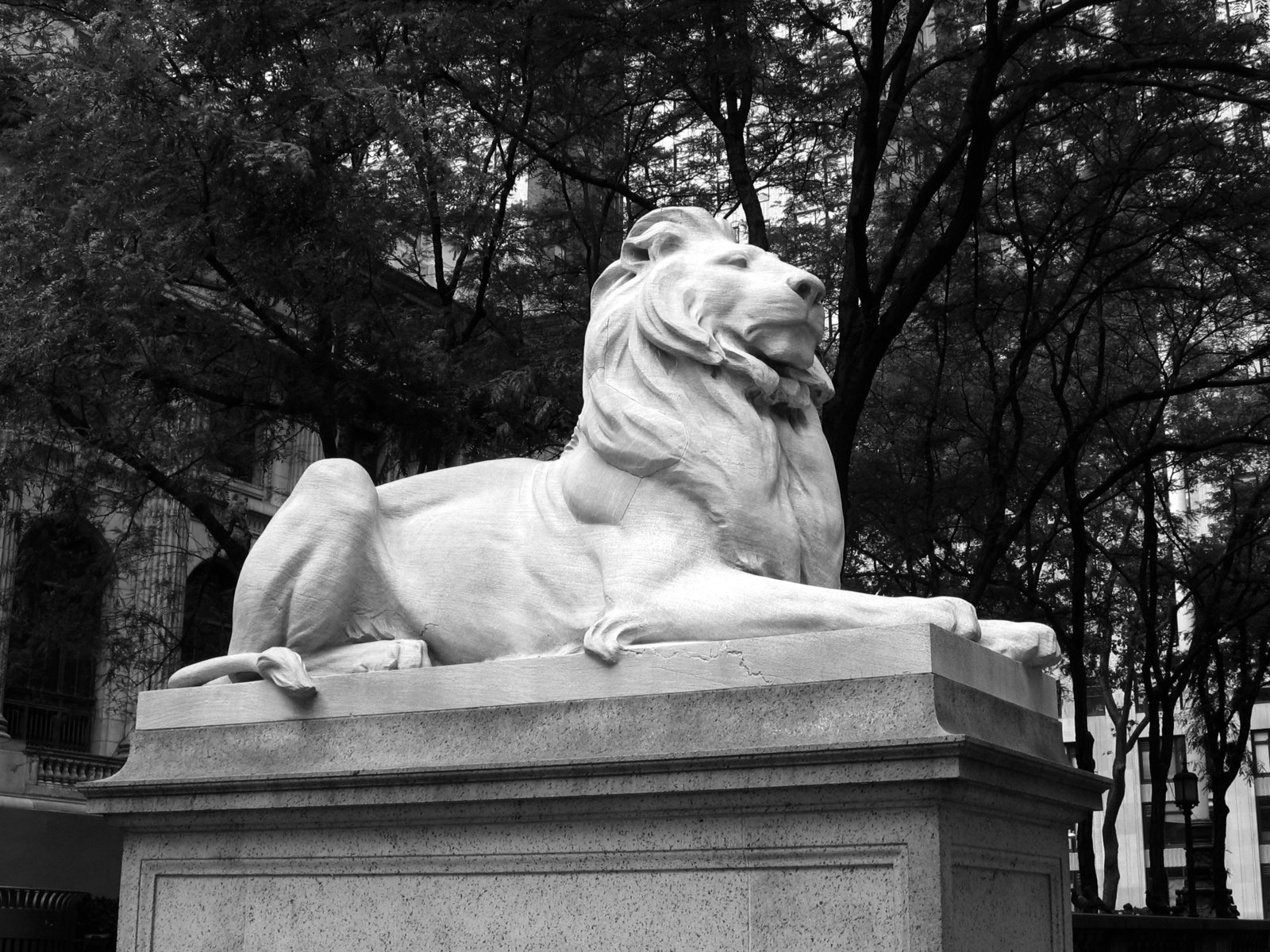 a lion statue with a building in the background