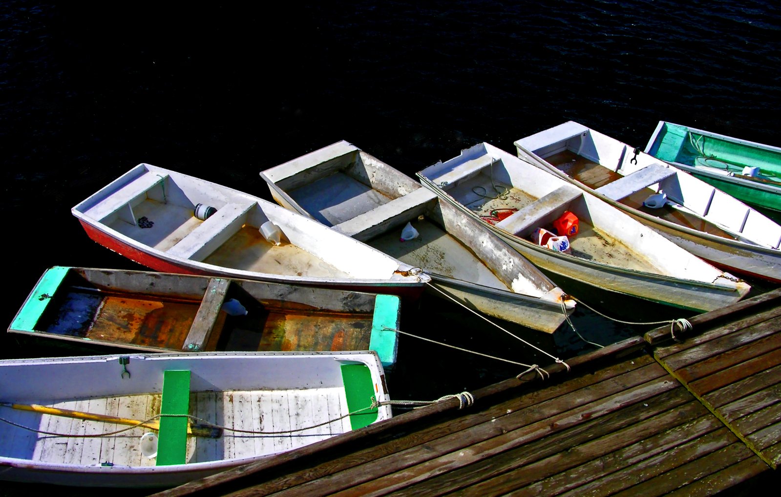 several small and large boats tied to a dock