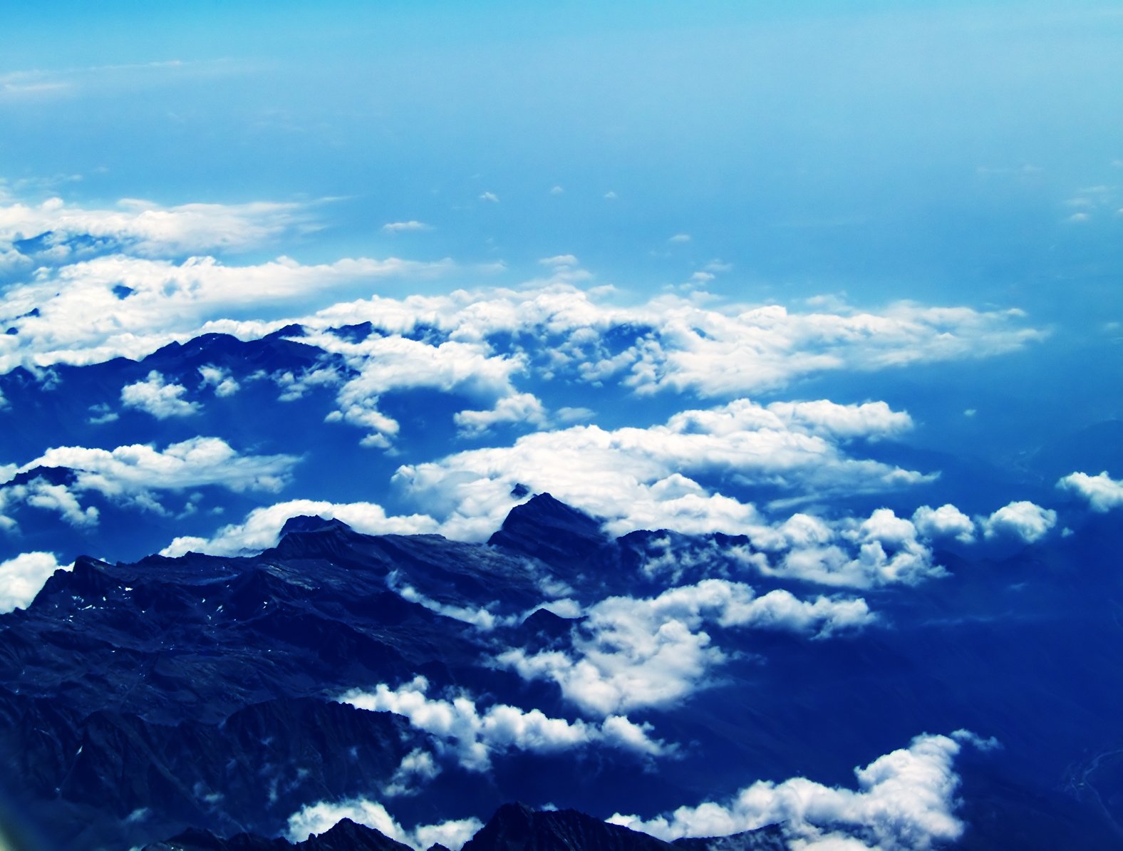 the top of some mountains are full of clouds