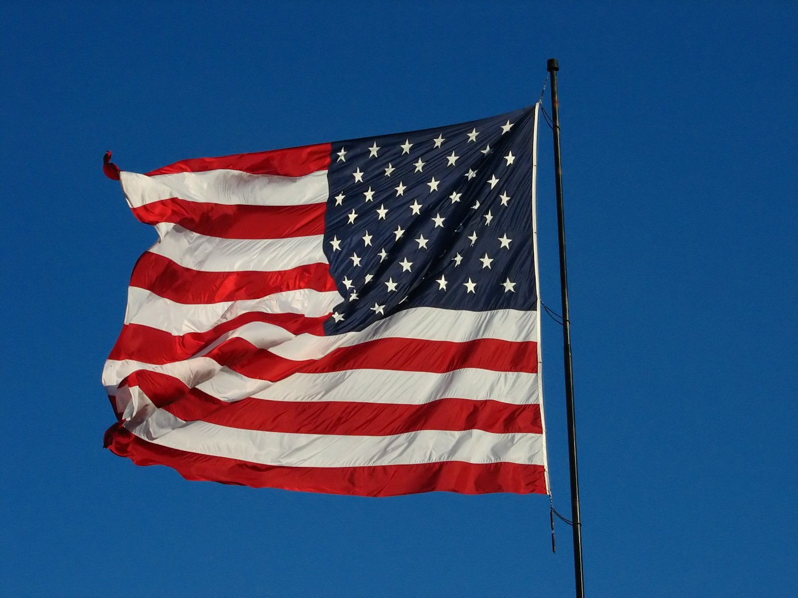 the american flag flies high in the blue sky