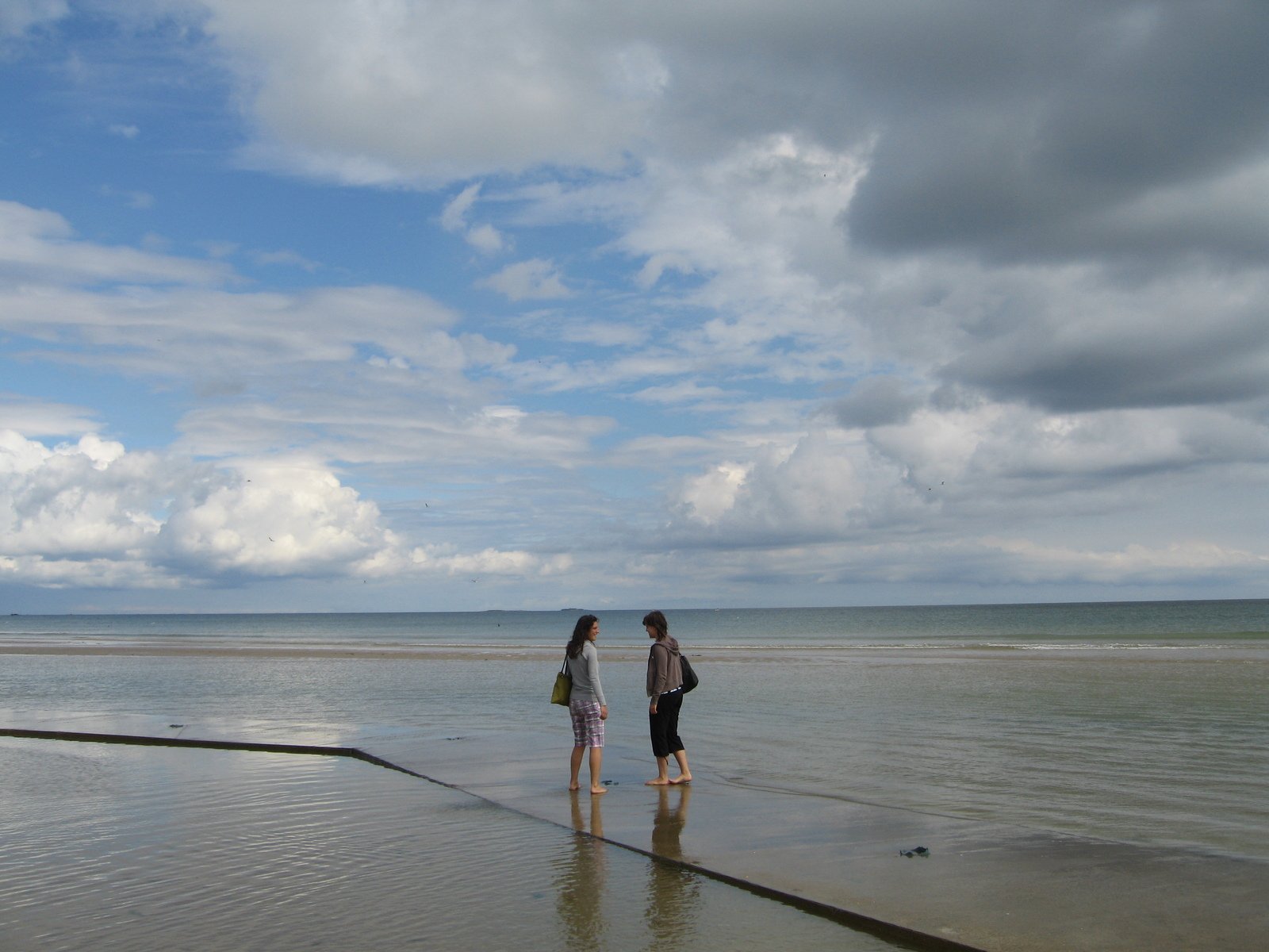 a couple of people standing on a beach