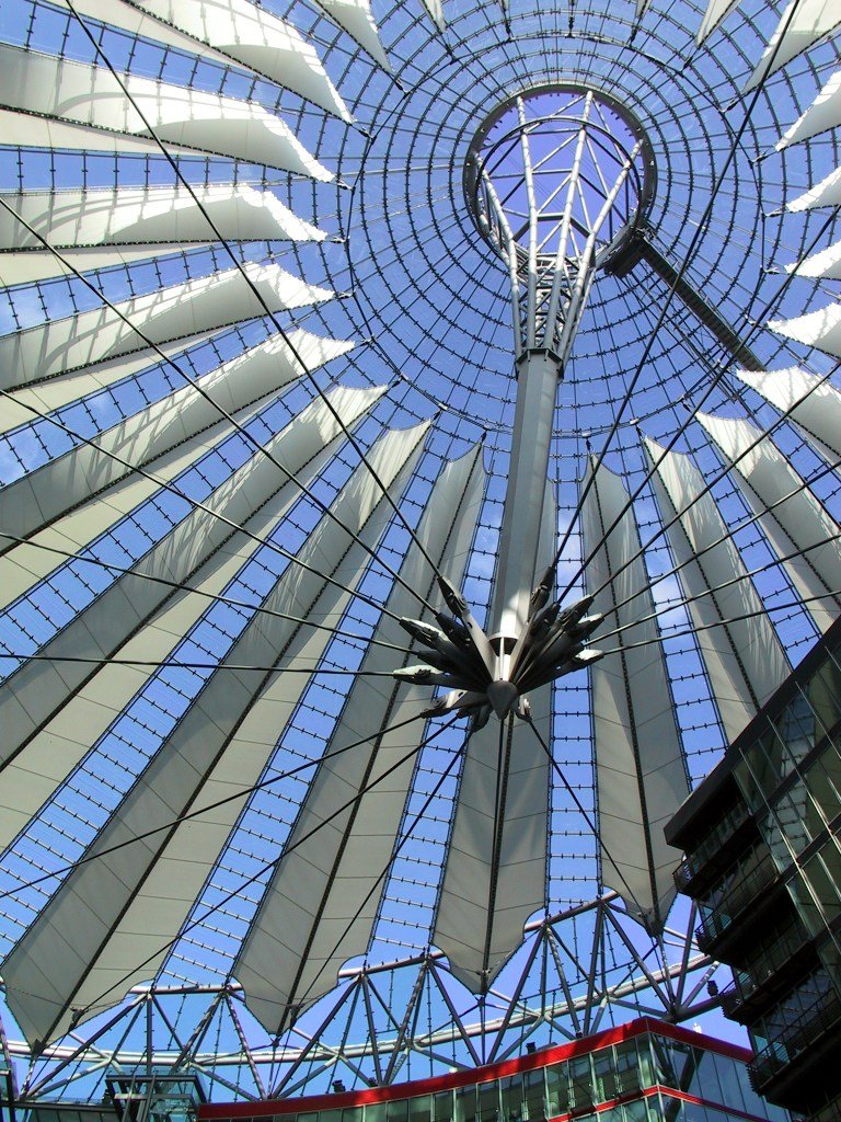a large atrium with a circular roof, glass walls and a skylight