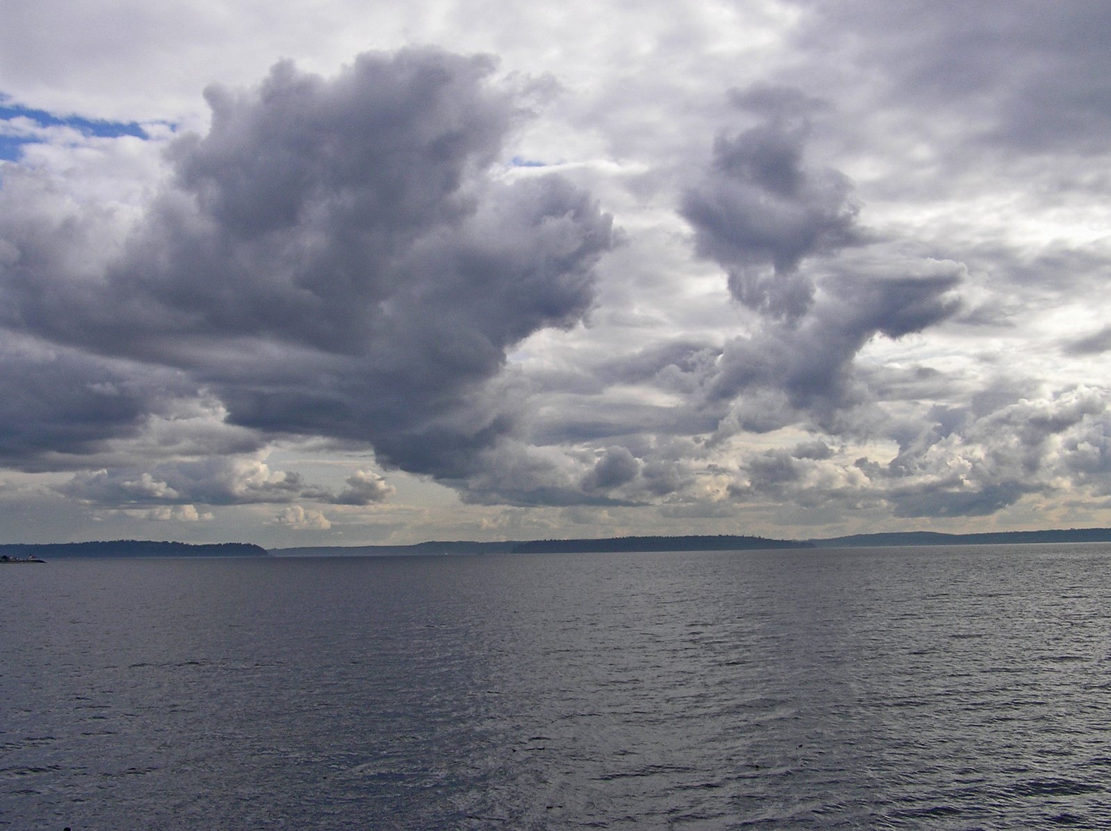 an ocean with lots of dark clouds above it