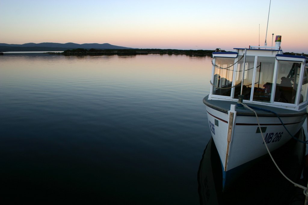 a small boat floating on top of a body of water