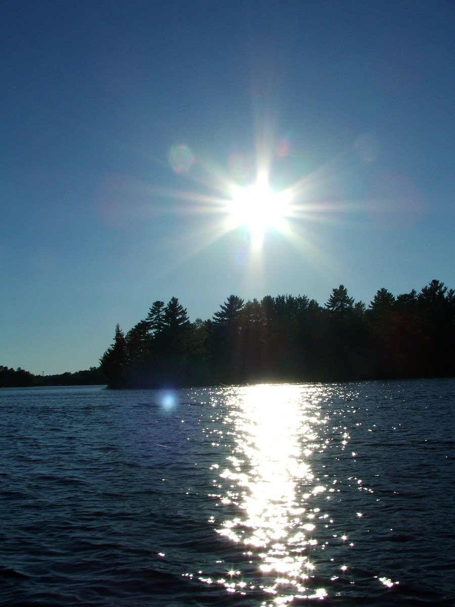 the sun over the ocean is reflected in the water