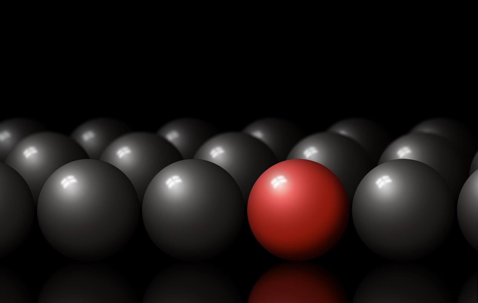 a red sphere in front of several dark gray balls