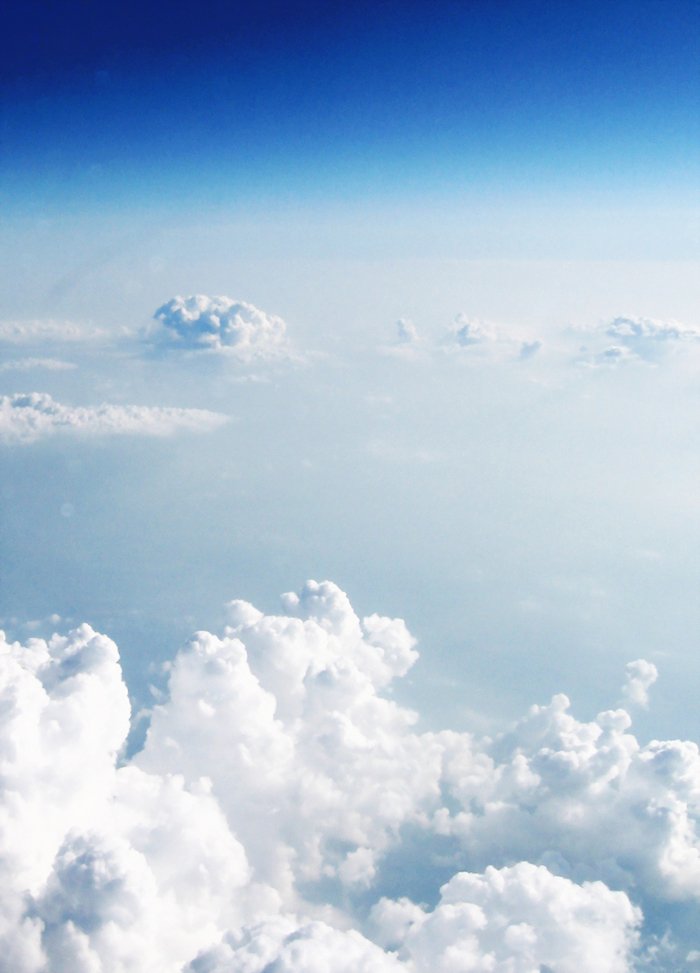 an airplane flying high up in the sky above clouds