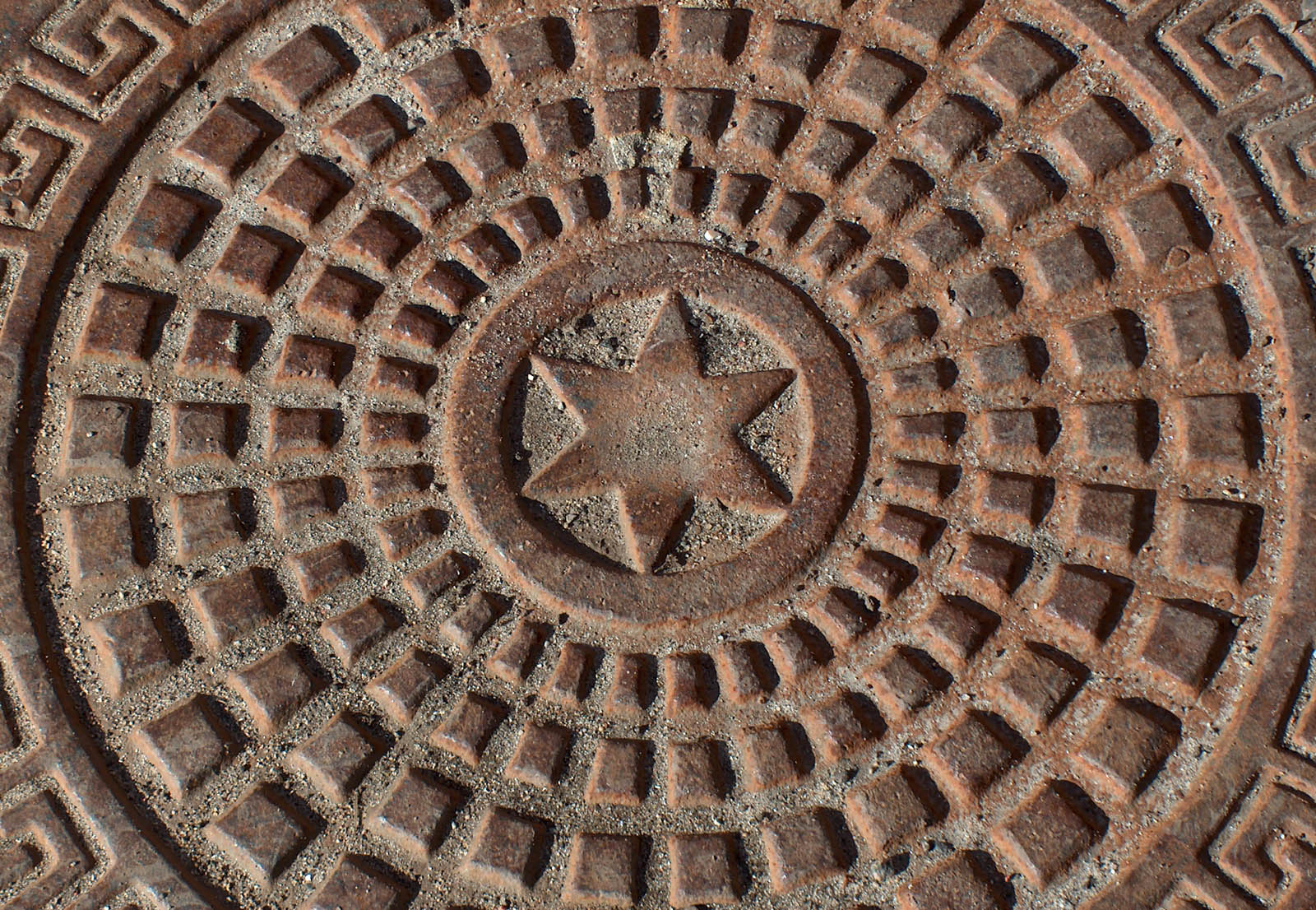 a circular drain with stars and shapes on it