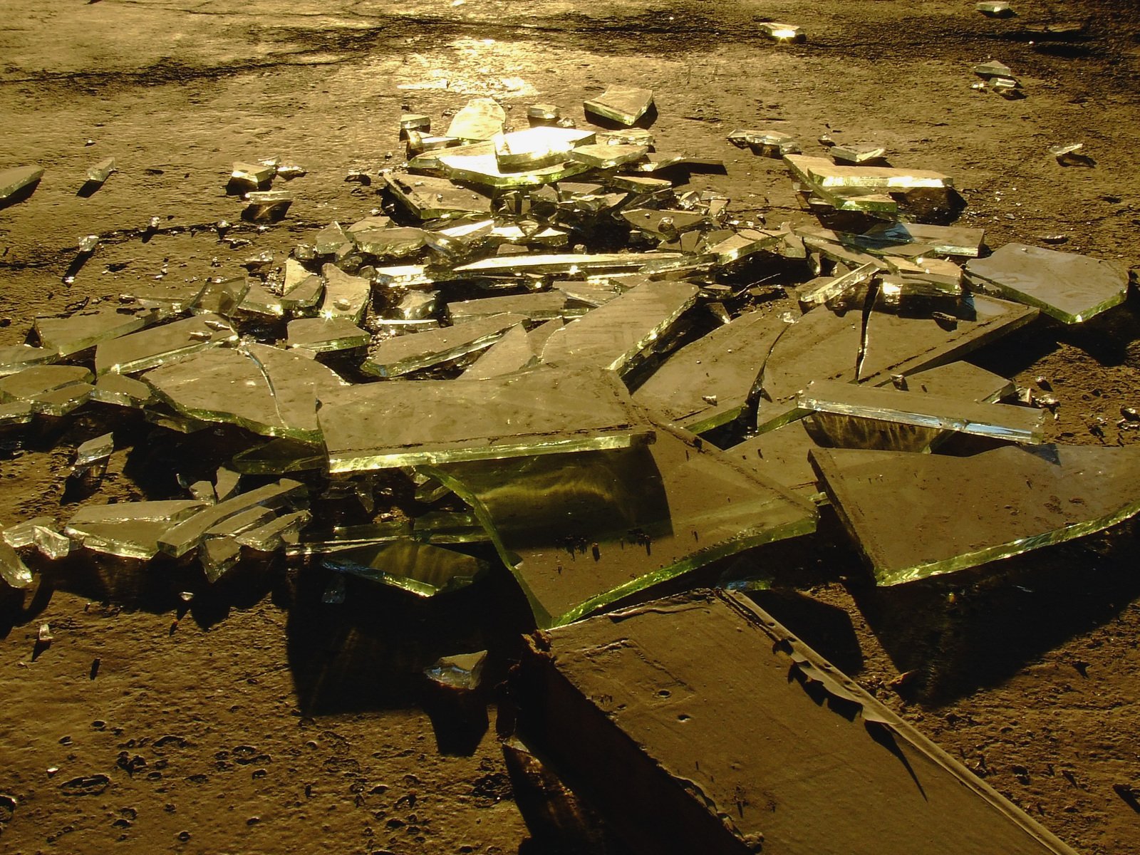 a bunch of broken mirrors sitting on top of dirt