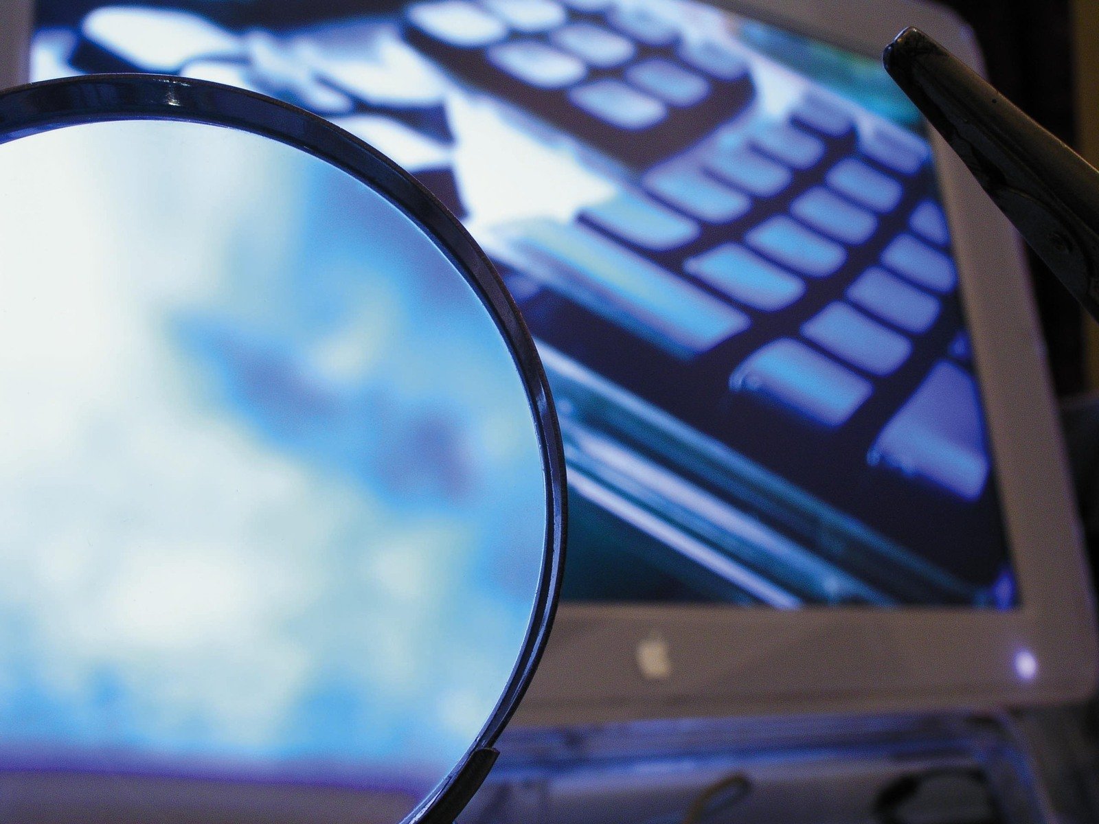 a computer screen behind a magnifying glass