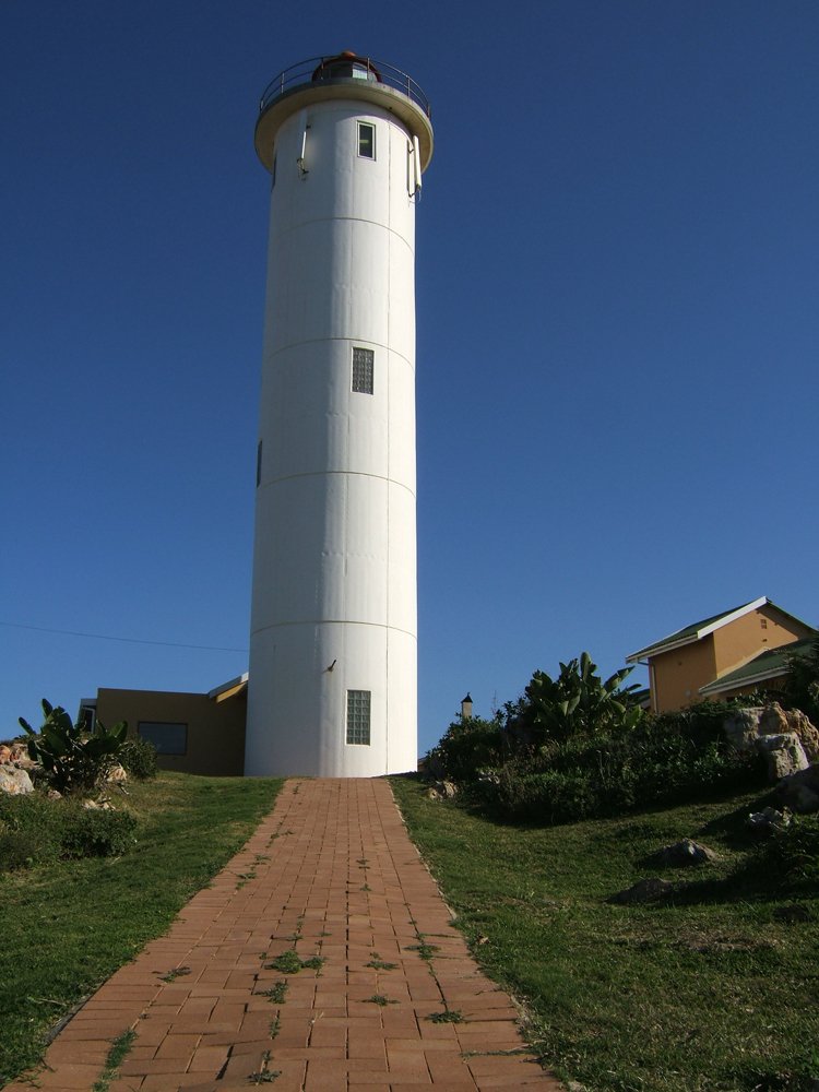 a lighthouse in a grassy area with a pathway to it