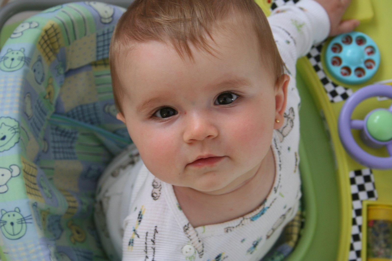 a baby is in a green toy chair