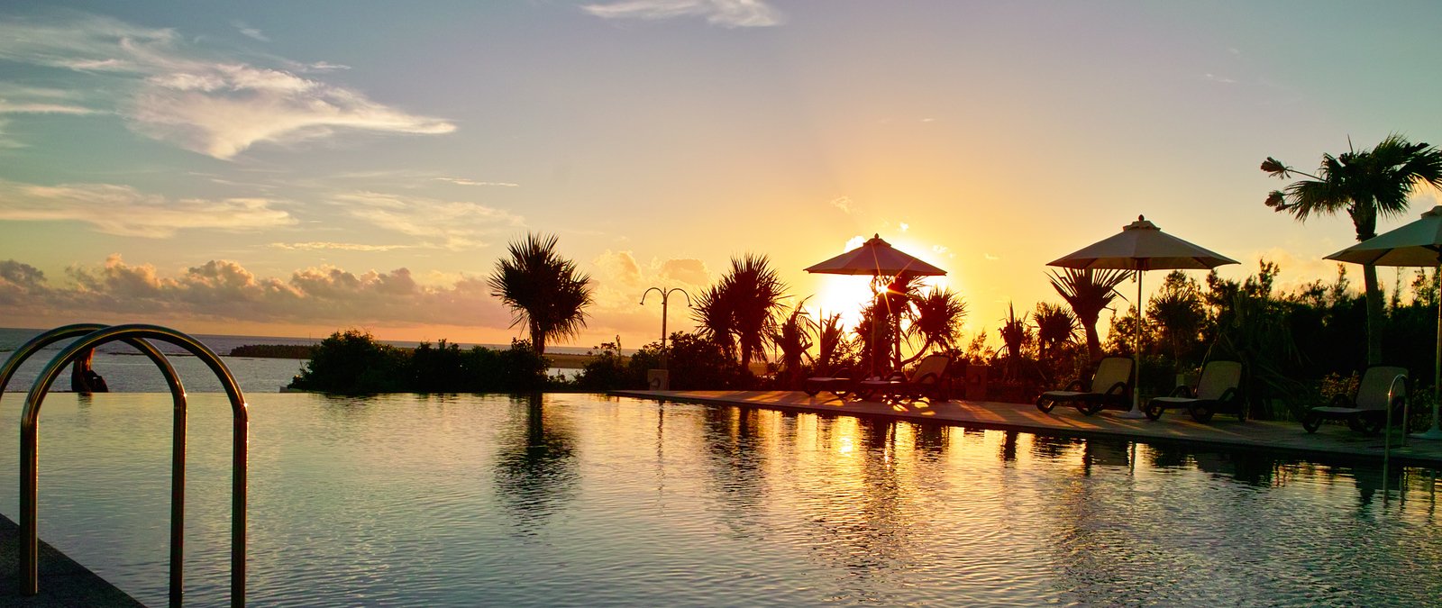 a large swimming pool with umbrellas next to it