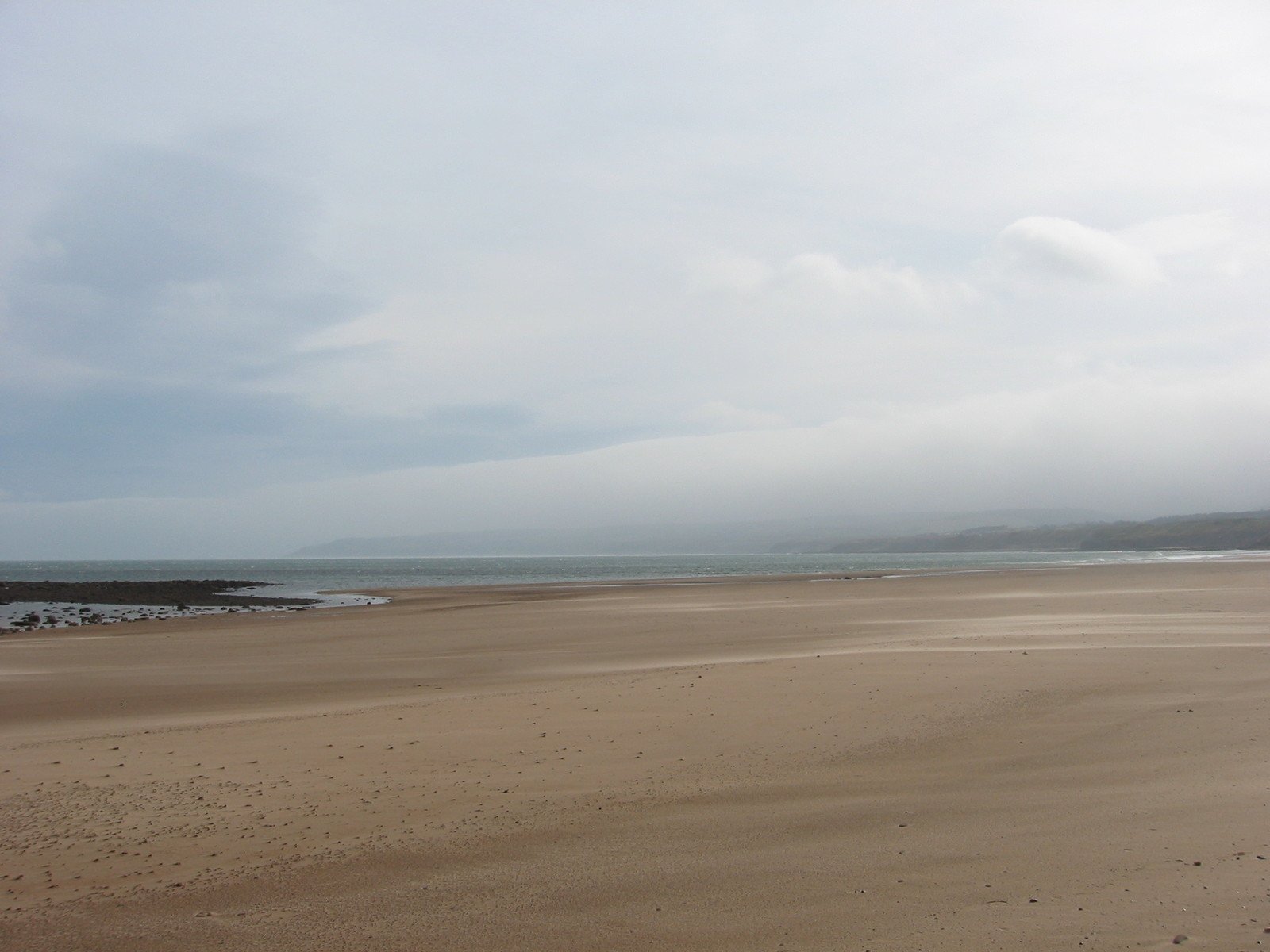 a person riding a surf board on a sandy beach