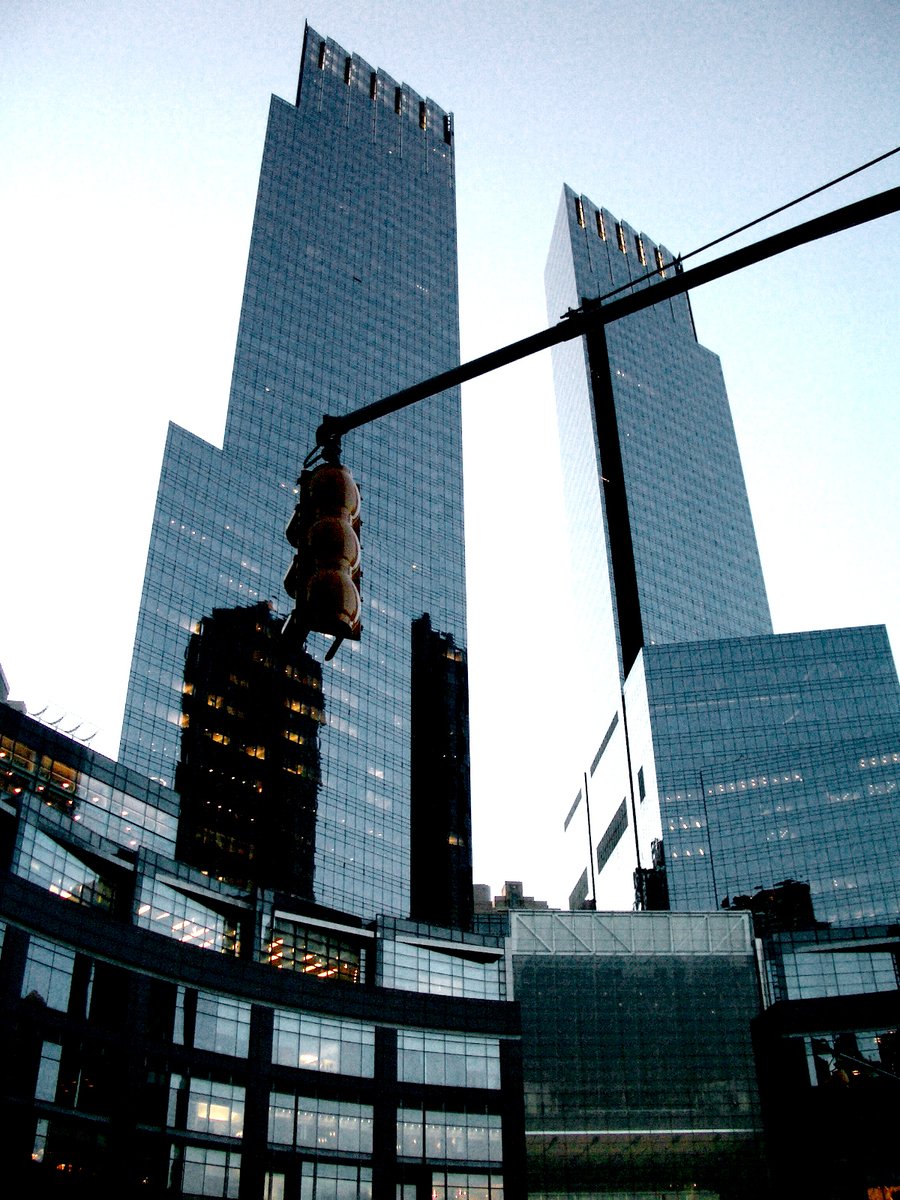 two tall buildings with different reflections behind them