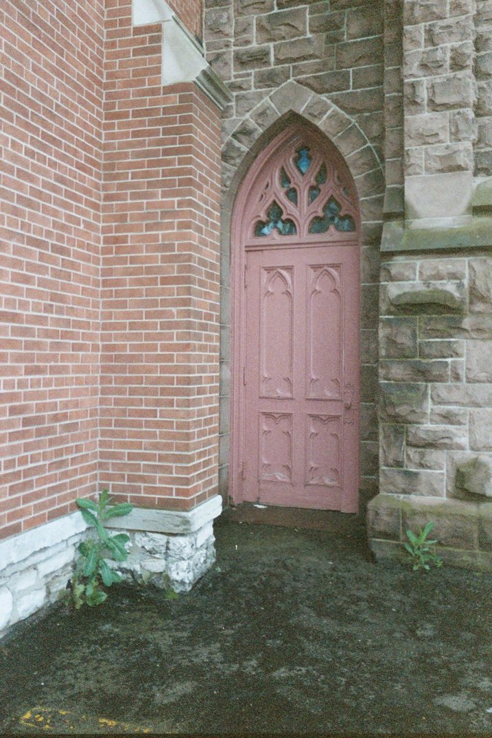 a red door in front of a brick building