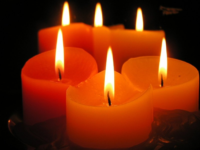 a group of white and orange candles sitting in front of each other