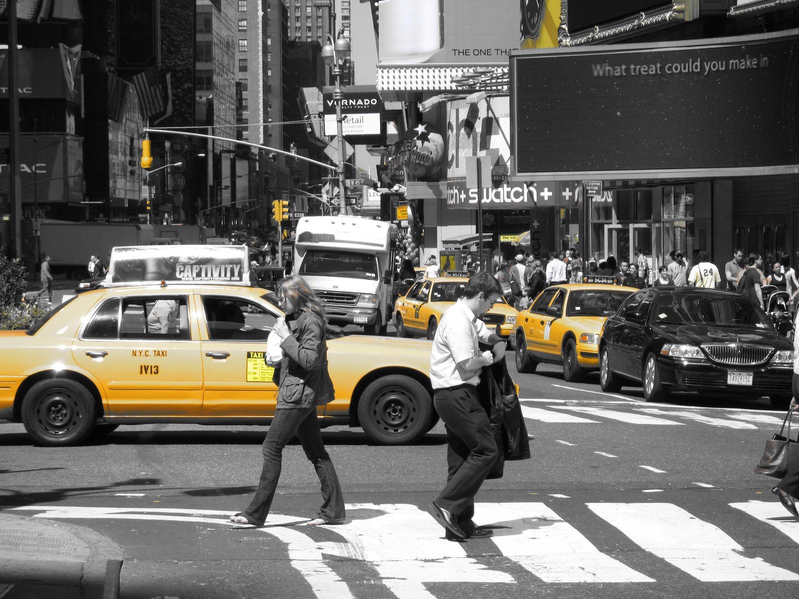 a yellow cab and other traffic is stopped at the crosswalk