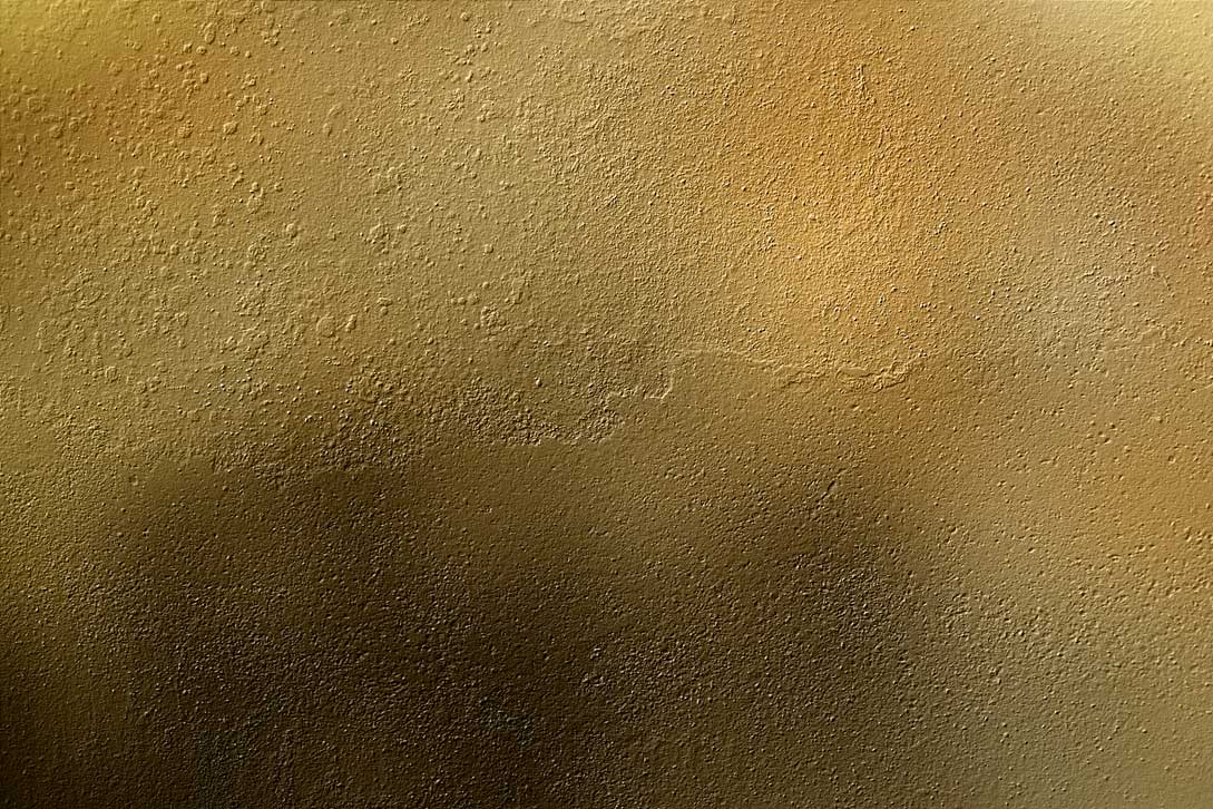 a light gold metal surface with scratches of paint