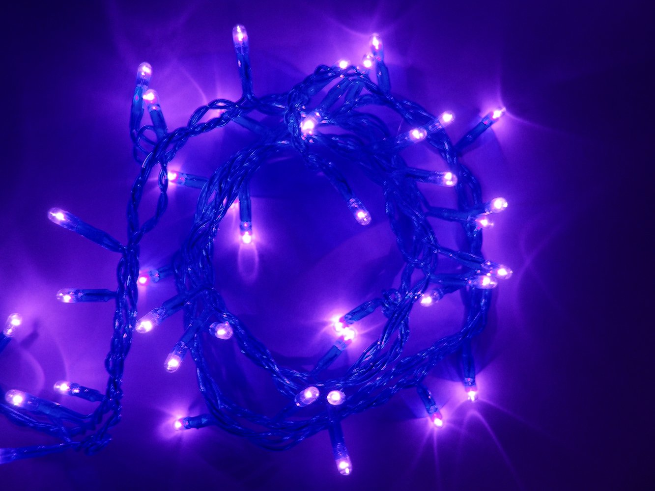a string of purple lights in the dark