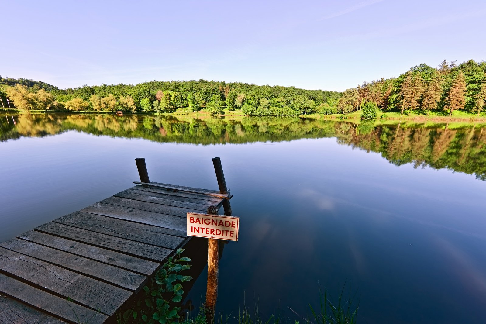a dock sitting on the shore of a lake with a sign that reads, don't enter