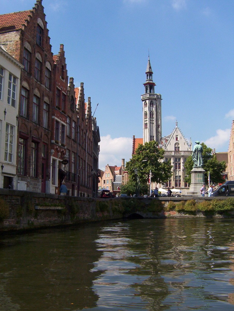 the tall tower of a building is sitting in the middle of some water