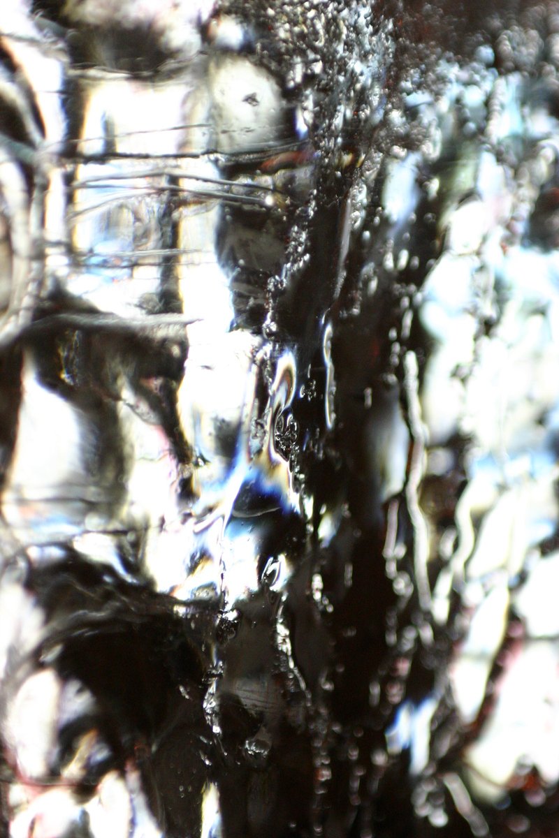water is dripping over a large structure of glass