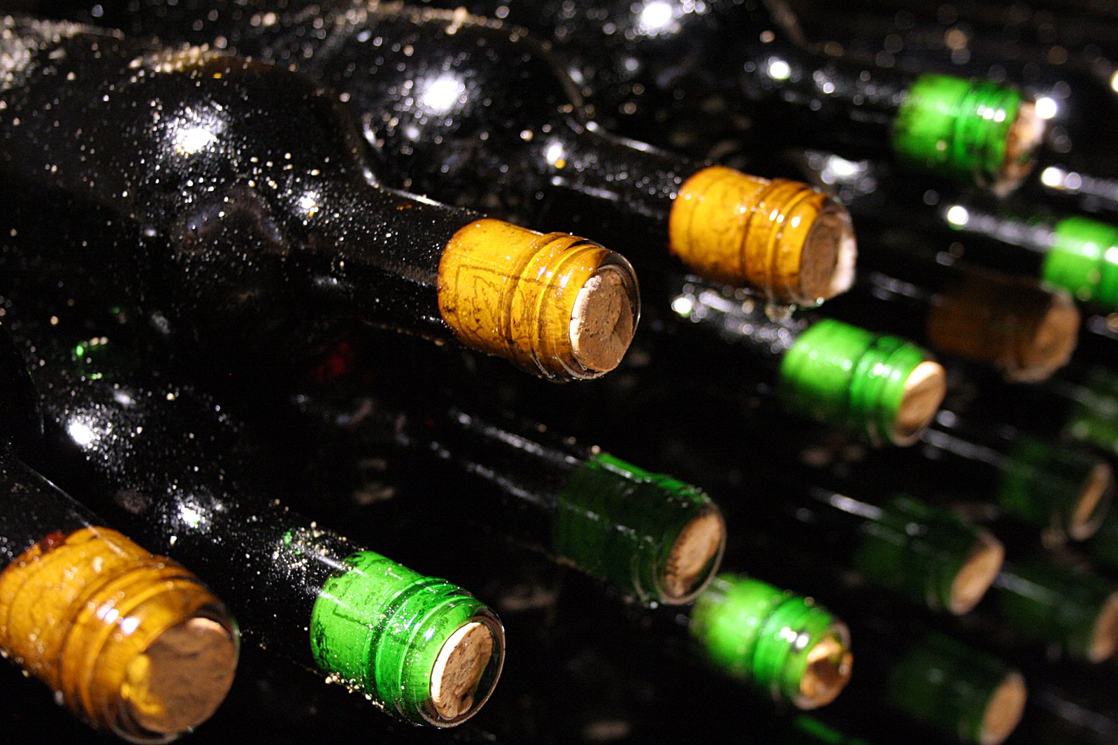 many wine bottles of various sizes are placed in a rack