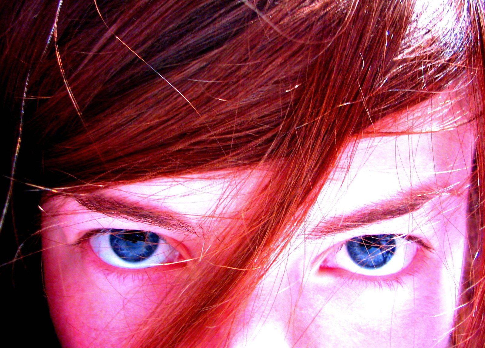 a woman has freckled her long hair and blue eyes