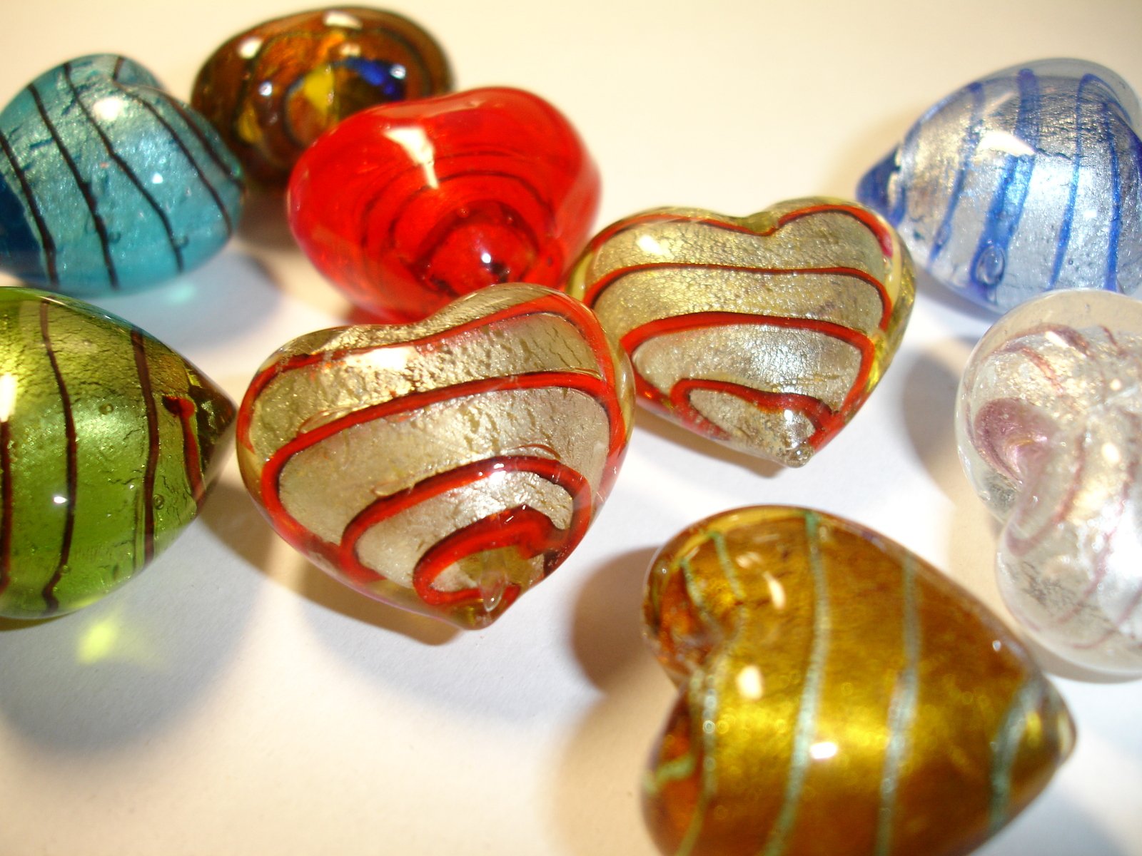 seven colorful blown glass ornaments sit in the middle of a white counter