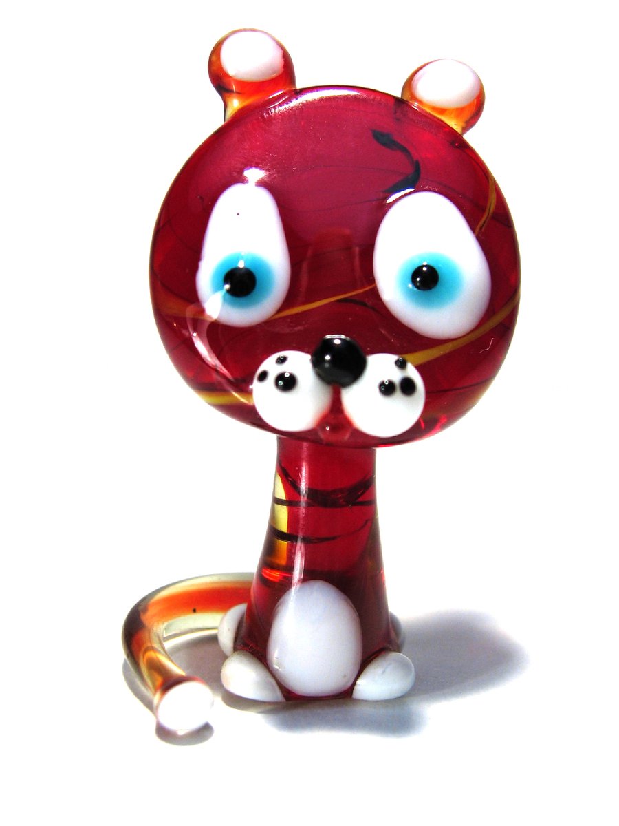 a red glass figurine with big eyes and claws
