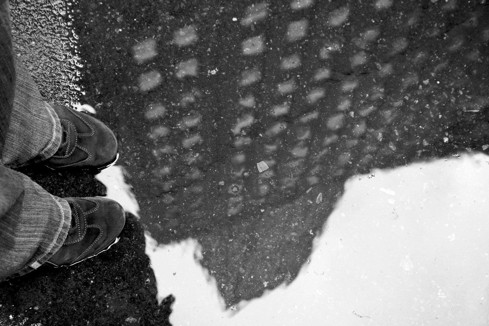 a man standing on a street with a umbrella reflecting in it