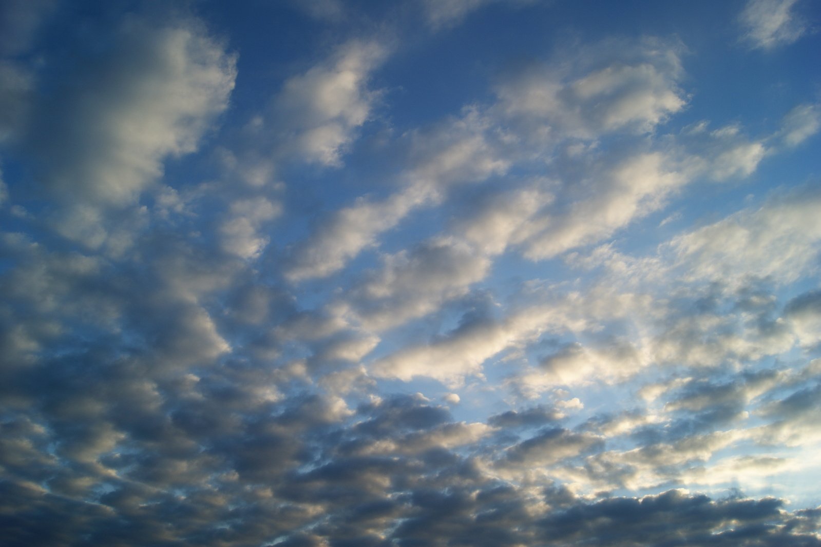 a plane is flying into the clouds with a blue sky