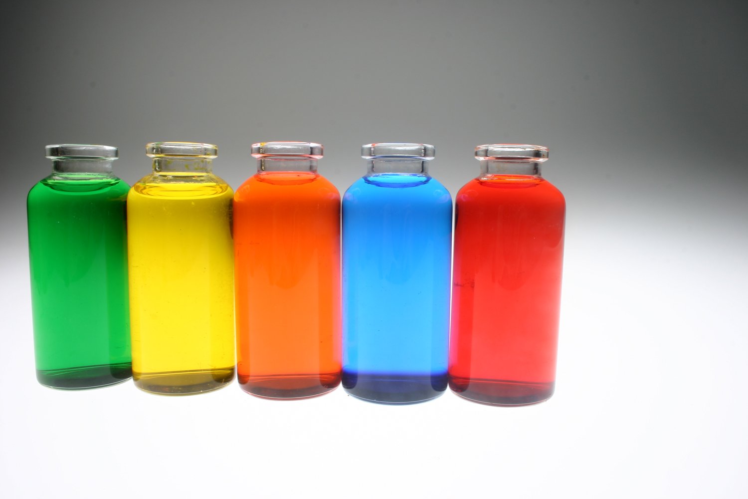 three small bottles in color sit next to each other