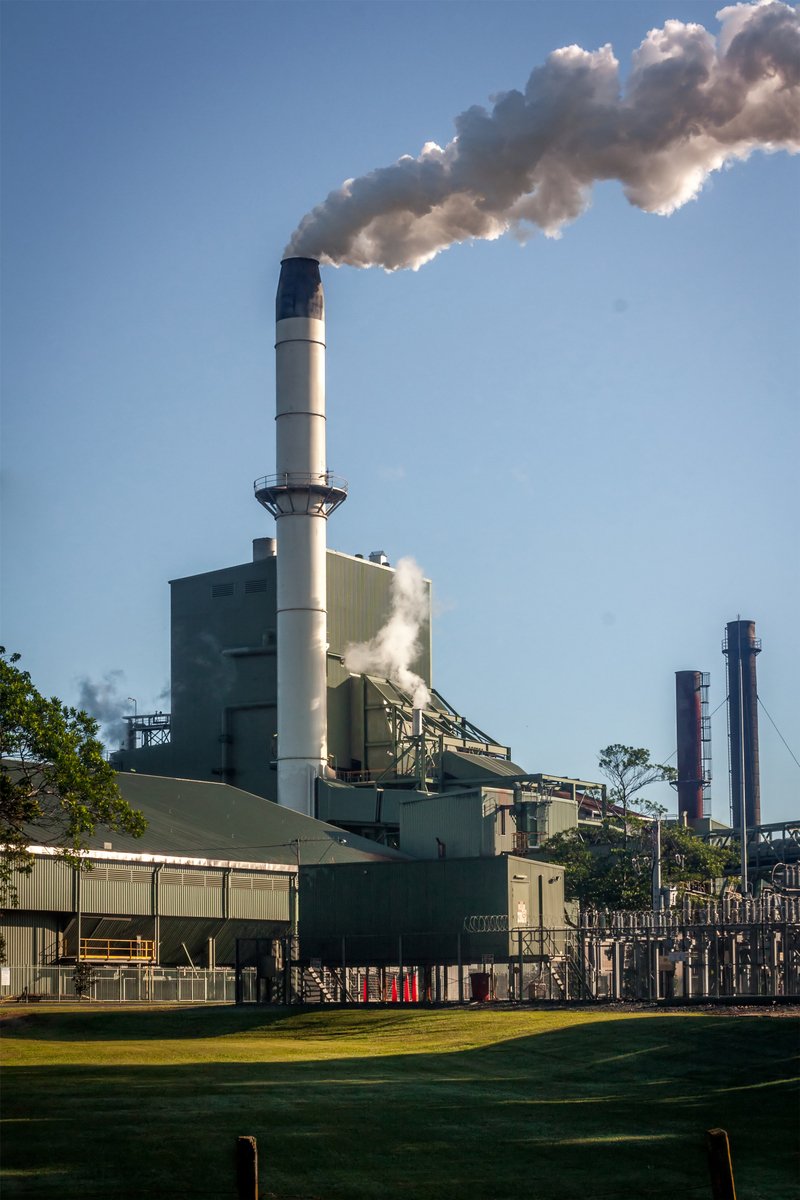 a factory smoking smoke pouring out of it's stacks