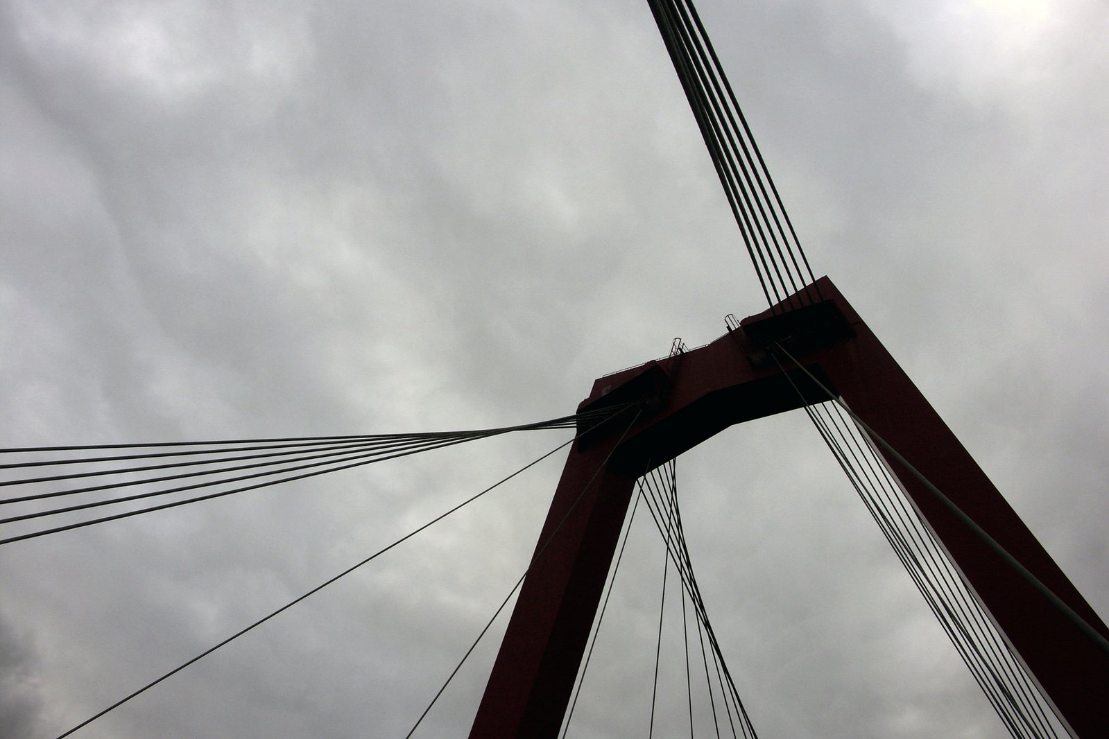a tall metal bridge with red colored posts on it