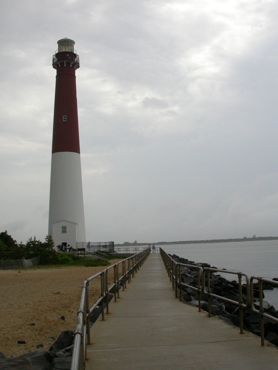 a red and white lighthouse sitting next to the ocean