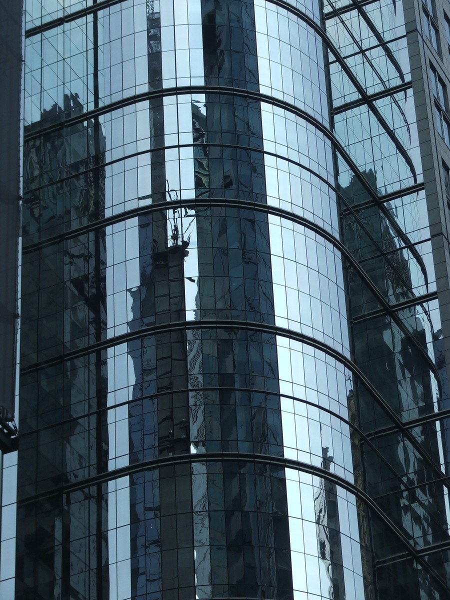 skyscrs reflected in glass windows on an urban street