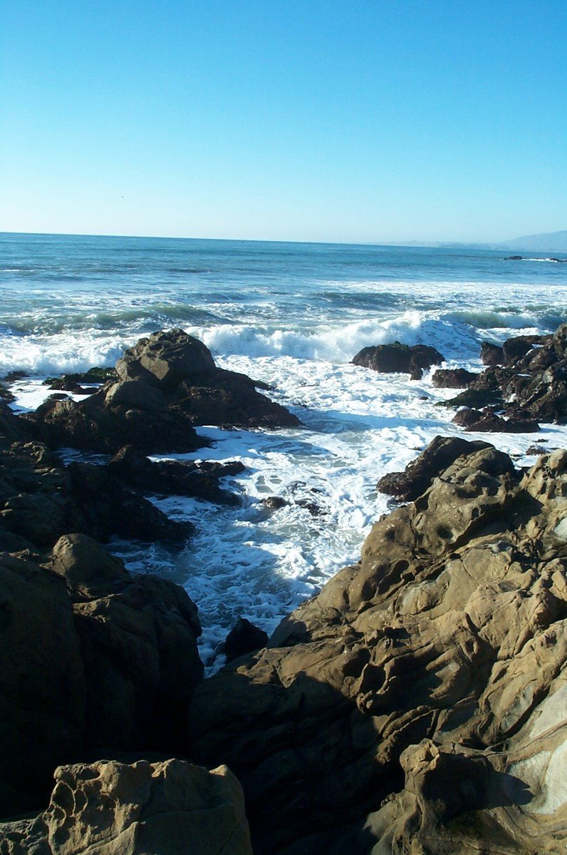 waves crashing onto a rocky shore near the ocean