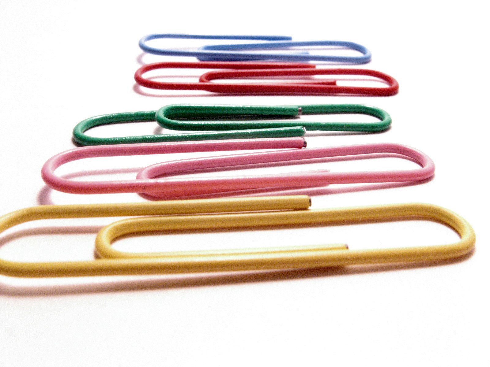 several colored paper clips laying next to each other