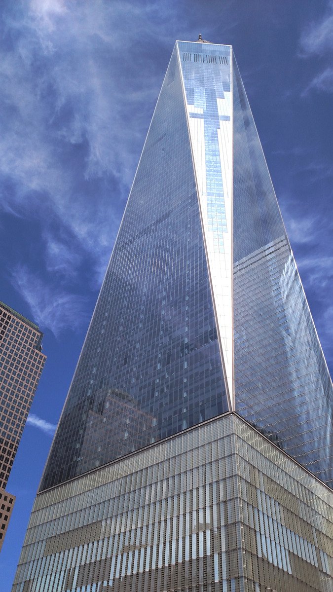 a very tall building near another building on the street