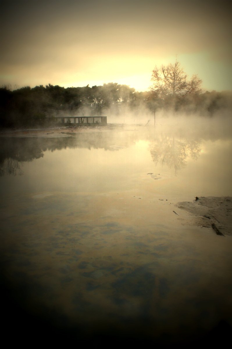an image of fog rising in the air next to water