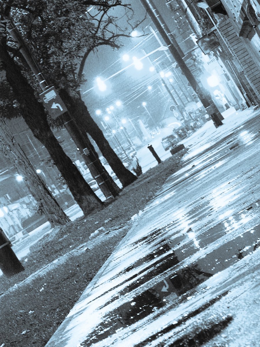 a black and white image of rain on a city street