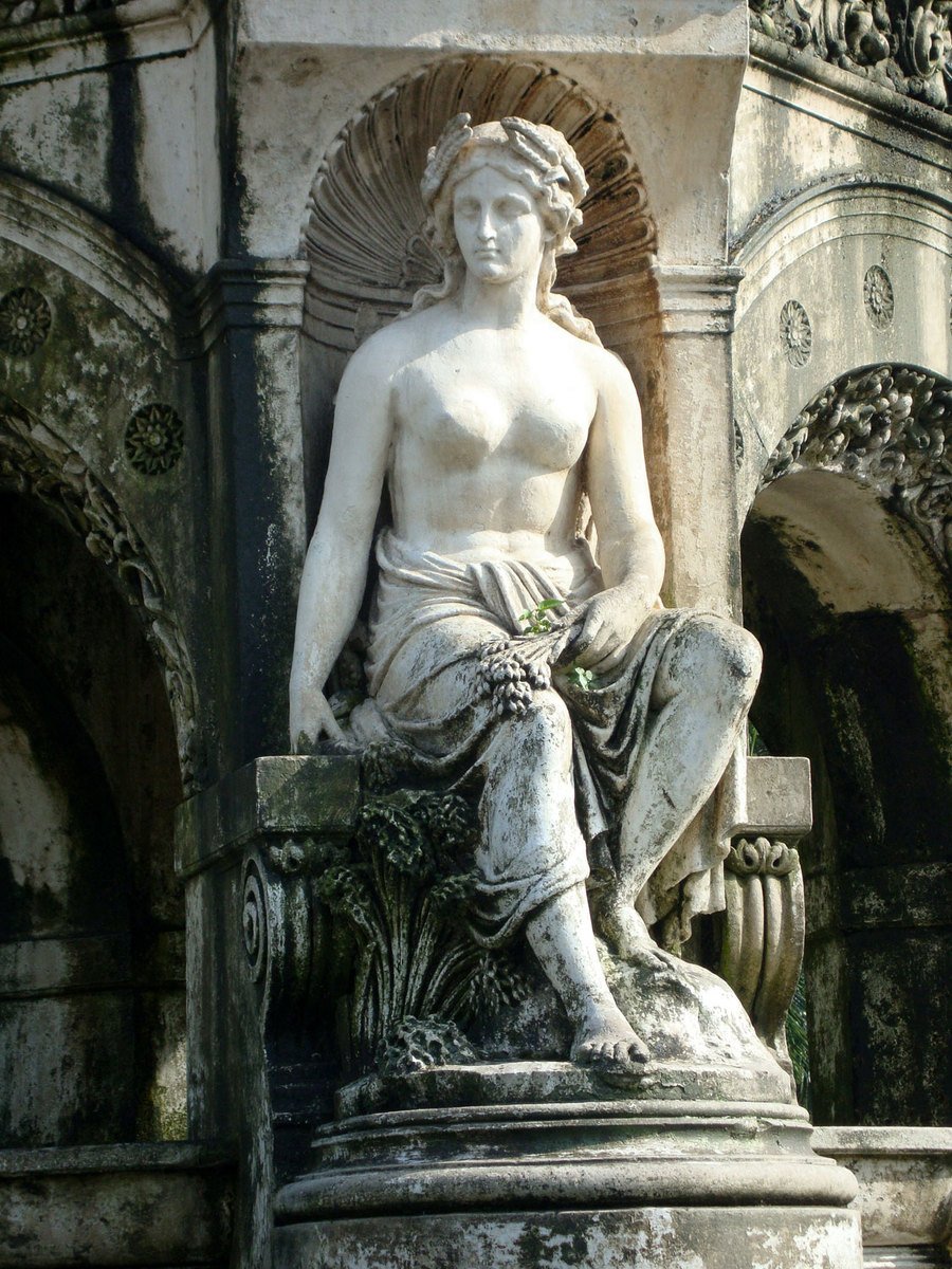 a stone statue is sitting on the steps