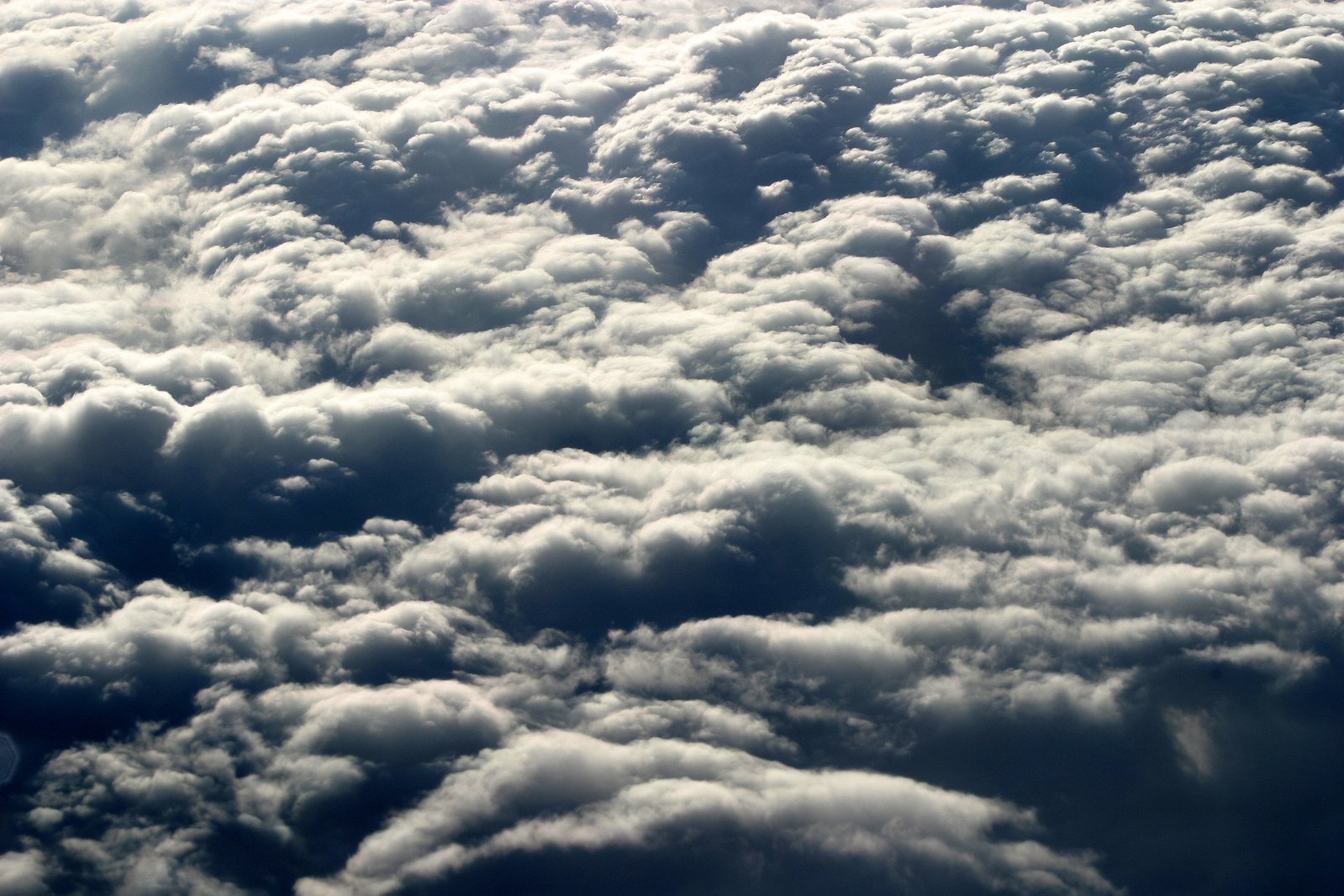 many clouds are forming and above a plane