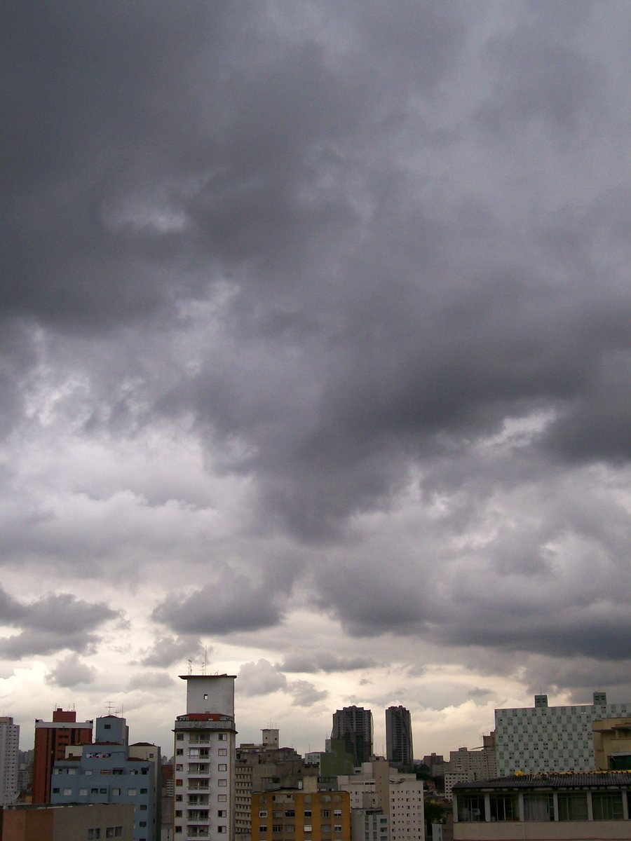 a cloudy sky with several buildings and clouds above